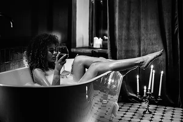 A woman sitting in a bathtub with her legs crossed.